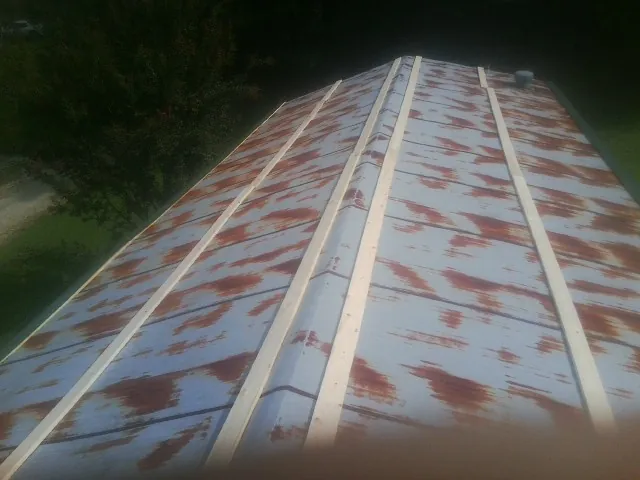Rusted metal roof panels with new wood purlins before replacement — Storm Damage Roof Repair in Coolville by Roofing Brothers
