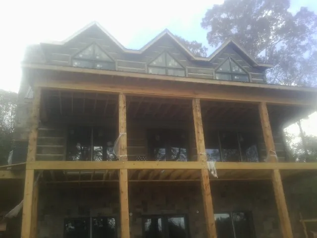 Dormers and porch framing on a large log home under construction — Roof Coating work by our crew in Coolville