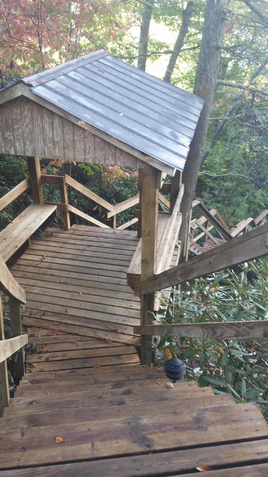 Metal roofed shelter over wooden steps on a wooded walkway — Skylight Repair & Installation work by our crew in Coolville