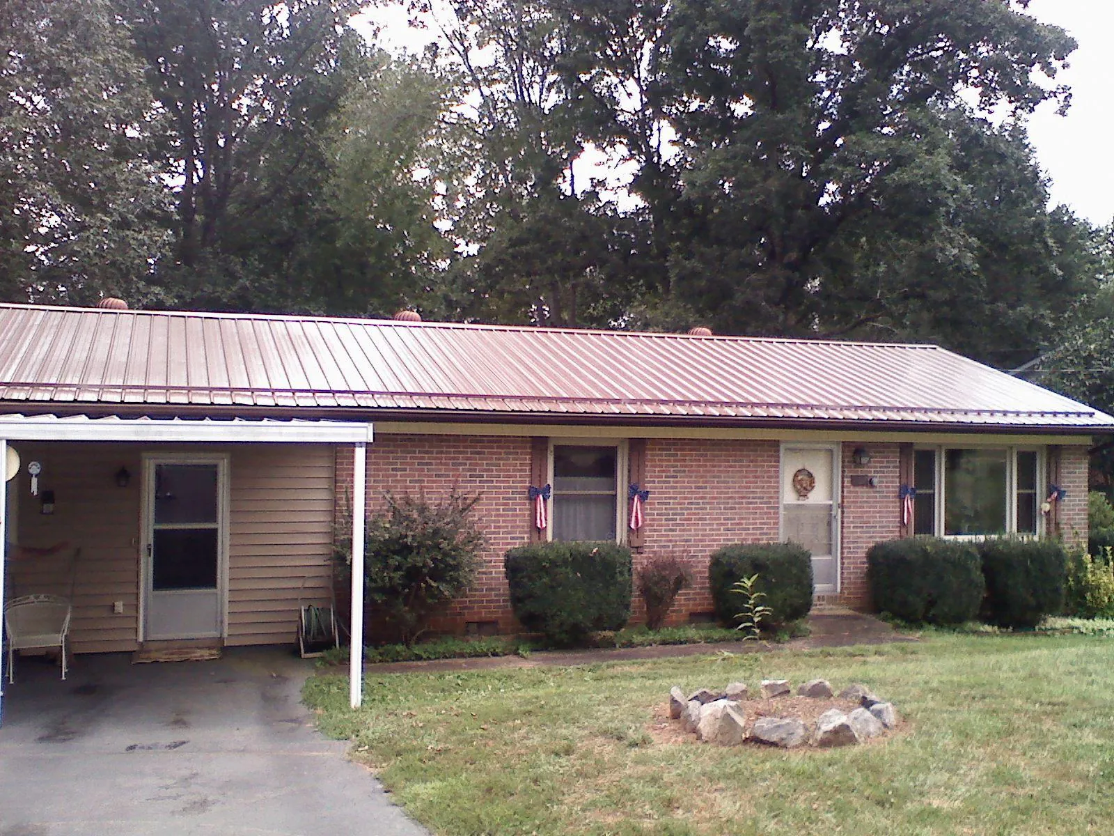 Bronze metal roof and carport on a brick ranch home — Roof Repair work by our crew in Coolville
