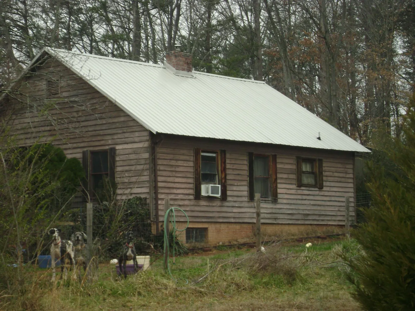White metal roof on an old wood sided farmhouse, from a Metal Roof Installation job in Coolville